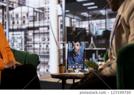 Multicultural team of businesswomen leads an online presentation, showcasing their leadership and success in a remote work environment. Sharing ideas with their boss on video call. Multicultural team of businesswomen leads an online presentation, showcasing their leadership and success in a remote work environment. Sharing ideas with their boss on video call. 125599780