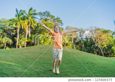 Boy wearing a pilot hat running through the grass with a toy airplane, dreaming of adventures. Childhood, imagination, and freedom concept Boy wearing a pilot hat running through the grass with a toy airplane, dreaming of adventures. Childhood, imagination, and freedom concept 125600373