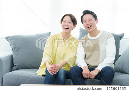 Young couple watching TV in the living room 125601365