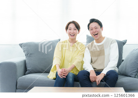 Young couple watching TV in the living room 125601366