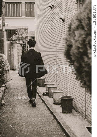 Street corner: back view of a man walking Street corner: back view of a man walking 125601375