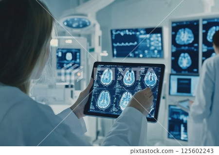 Medical professionals analyze brain scans using a tablet in a high-tech hospital setting 125602243