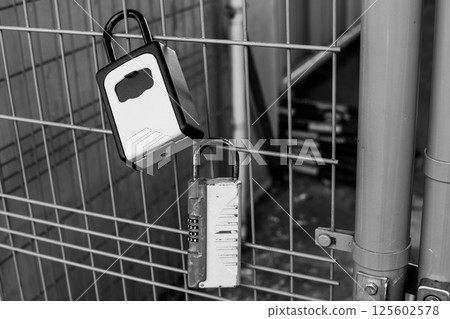Key box attached to public property in the city center, monochrome Key box attached to public property in the city center, monochrome 125602578