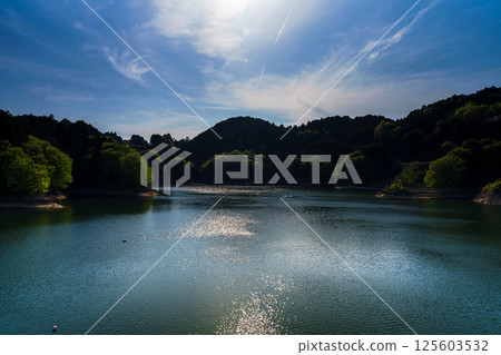 Clouds flowing on the ceaseless wind and reflections on the swaying lake surface at Nunome Dam with fresh greenery③ 125603532