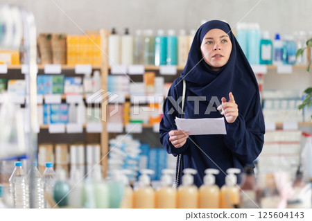 Mom and daughter looking for something in drugstore Mom and daughter looking for something in drugstore 125604143