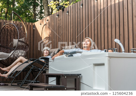 A couple of sauna lovers bathing in the open air while wearing sauna hats A couple of sauna lovers bathing in the open air while wearing sauna hats 125604236