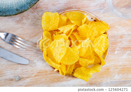 Delicious crispy potato chips in plate on table. Top view 125604271