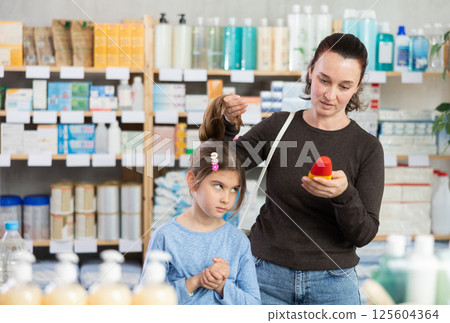 Woman checks daughter's hair on lice 125604364