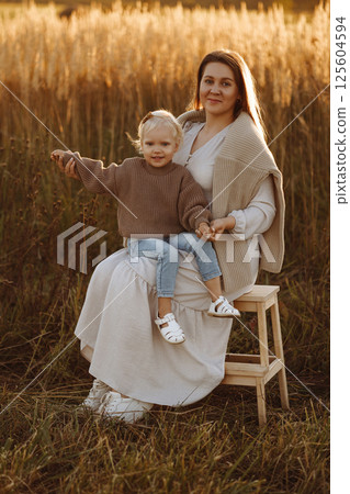 Mother and Daughter Smiling in Wheat Field at Sunset 125604594