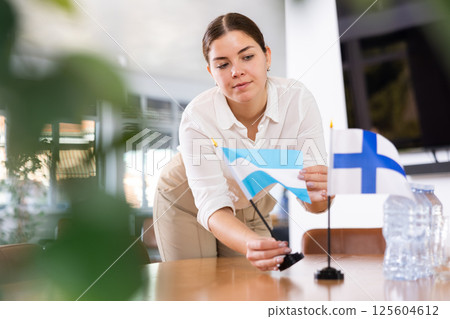 female assistant prepares conference room for diplomats of Finland and Argentina 125604612