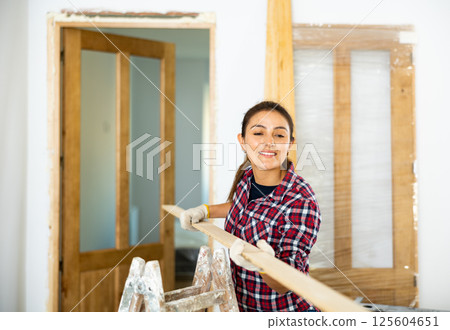Woman prepares place to install door in doorway 125604651