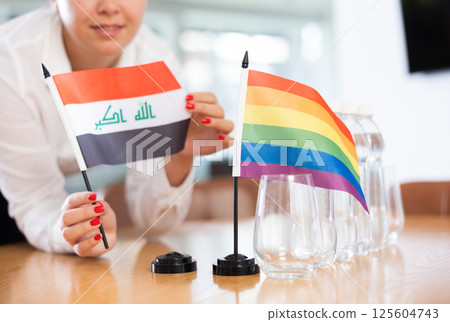 Flags of Iraqi and LGBT stand on negotiating table in office Flags of Iraqi and LGBT stand on negotiating table in office 125604743