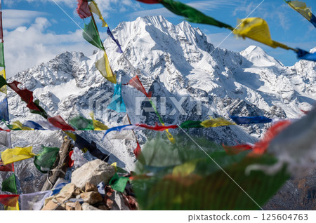 Beautiful view of Mt.Naya Kanga look through prayer flags in Langtang valley of Nepal seen from Tsergo Ri (4,990m) the high point on the Langtang valley trek of Nepal. 125604763