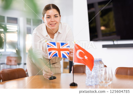 female assistant prepares conference room for diplomats of Turkey and Great Britain female assistant prepares conference room for diplomats of Turkey and Great Britain 125604785