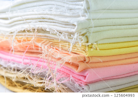 stack of colourful cotton clothes, close up pile of clothing 125604993