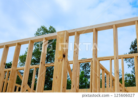 Workers construct wooden frame showcasing progress on residence under works day 125606027