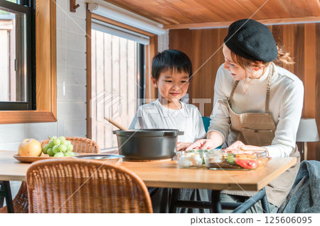 Family staying in a bungalow/cottage and preparing meals together (family trip/glamping) 125606095