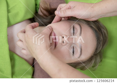Top view of woman getting facial massage. Top view of woman getting facial massage. 125606214