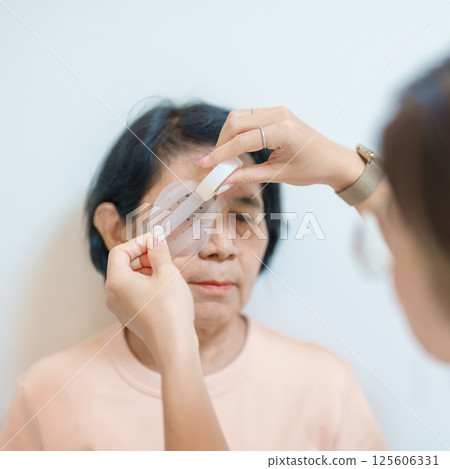 Senior Woman during eye protecting by shield after eye surgery. Eye disease, Cataract, Glaucoma, Age Related Macular Degeneration, Diabetic Retinopathy, Vitreous, Lasik, World Glaucoma day and health Senior Woman during eye protecting by shield after eye surgery. Eye disease, Cataract, Glaucoma, Age Related Macular Degeneration, Diabetic Retinopathy, Vitreous, Lasik, World Glaucoma day and health 125606331