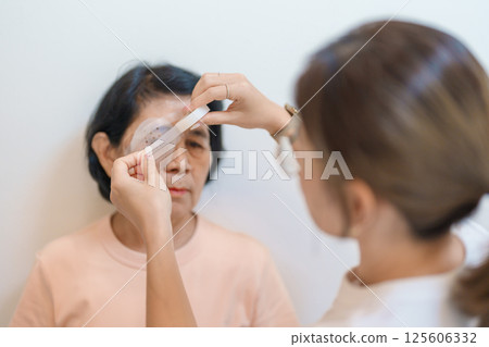 Senior Woman during eye protecting by shield after eye surgery. Eye disease, Cataract,  Glaucoma, Age Related Macular Degeneration, Diabetic Retinopathy, Vitreous, Lasik, World Glaucoma day and health 125606332