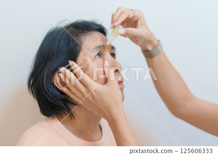 Elderly Woman use ophthalmic solutions or Eye Drops after eye surgery. Eye disease, Cataract, Glaucoma, Age Related Macular Degeneration, Diabetic Retinopathy, World Glaucoma day and health treatment Elderly Woman use ophthalmic solutions or Eye Drops after eye surgery. Eye disease, Cataract, Glaucoma, Age Related Macular Degeneration, Diabetic Retinopathy, World Glaucoma day and health treatment 125606333