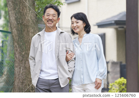 Middle-aged couple walking arm in arm outdoors 125606760