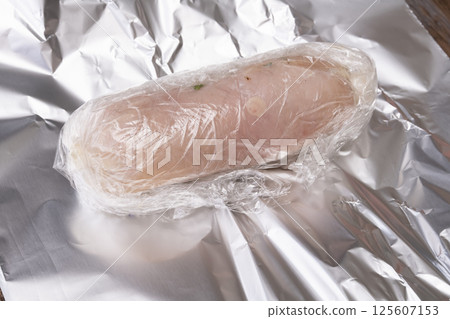 The process of making chicken ham: Pound, stretch, roll and boil chicken breast meat. The process of making chicken ham: Pound, stretch, roll and boil chicken breast meat. 125607153