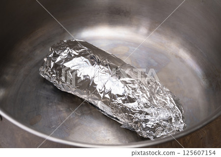 The process of making chicken ham: Pound, stretch, roll and boil chicken breast meat. 125607154