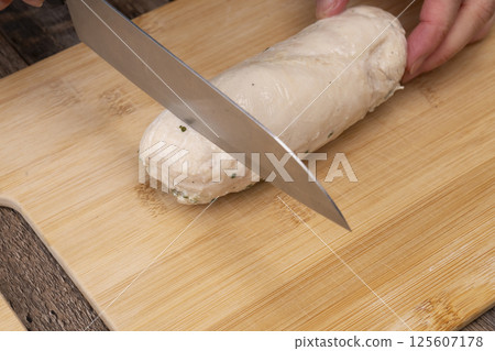 雞肉火腿的製作過程：用刀將做好的雞肉火腿切開，擺放在砧板上 125607178