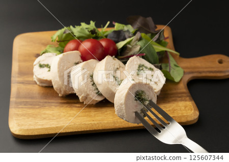 Lift the chicken ham wrapped in parsley and onion with a fork 125607344