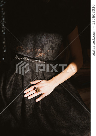 Elegant Black Dress with Ring in Dramatic Lighting 125608036
