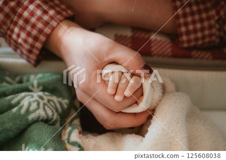 Tender Moment of Parent Holding Baby's Hand 125608038