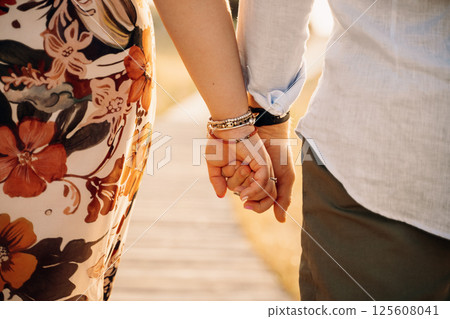 Close-Up of Couple Holding Hands on a Sunny Day 125608041