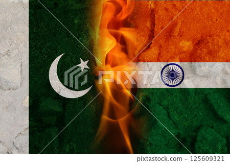Abstract representation of India and Pakistan flags with flames and fire symbolizing conflict and tension along the border, with a military backdrop evoking a sense of war and unrest 125609321