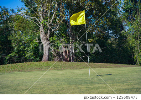 Background of evening golf course has sunlight shining down at golf course. 125609475