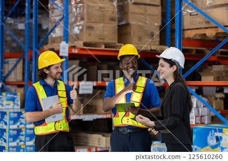Happy warehouse workers thumb up to female supervisor Achievement of work management goals in storage department. Happy warehouse workers thumb up to female supervisor Achievement of work management goals in storage department. 125610260