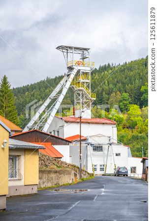 The mining tower in Jachymov is a significant landmark, surrounded by a quaint neighborhood and lush green hills. It highlights the area's mining heritage and industrial history. The mining tower in Jachymov is a significant landmark, surrounded by a quaint neighborhood and lush green hills. It highlights the area's mining heritage and industrial history. 125611879
