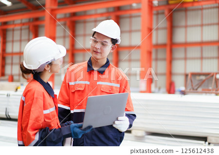 Team of Asian mechanical engineers is having a discussion inside the factory, with the chief engineer talking to his team. Engineer is briefing his team in the morning before they begin their work. Team of Asian mechanical engineers is having a discussion inside the factory, with the chief engineer talking to his team. Engineer is briefing his team in the morning before they begin their work. 125612438