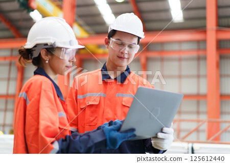 Team of Asian mechanical engineers is having a discussion inside the factory, with the chief engineer talking to his team. Engineer is briefing his team in the morning before they begin their work. Team of Asian mechanical engineers is having a discussion inside the factory, with the chief engineer talking to his team. Engineer is briefing his team in the morning before they begin their work. 125612440