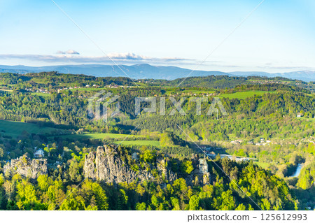 Visitors enjoy breathtaking vistas at Pantheon Lookout in Bohemian Paradise, overlooking lush greenery and the majestic Krkonose Mountains in the background. A perfect hiking destination. 125612993