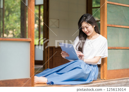 年輕女子看著平板電腦並使用觸控控制 125613014