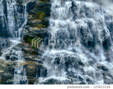 Aerial view of a waterfall in a lush tropical green forest in Doi Inthanon National Park, Chiang Mai, Thailand. This nature landscape showcases water sustainability and scenic travel destinations. 125613126