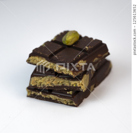 Delicious kadaif layers with rich chocolate and pistachio topping displayed on a clean, white Delicious kadaif layers with rich chocolate and pistachio topping displayed on a clean, white 125613652