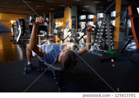 Overhead view portrait of teenage boy training with dumbbells 125613701