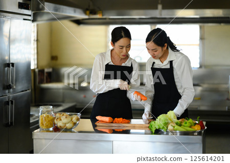Female culinary student preparing fresh vegetables during a cooking class Female culinary student preparing fresh vegetables during a cooking class 125614201