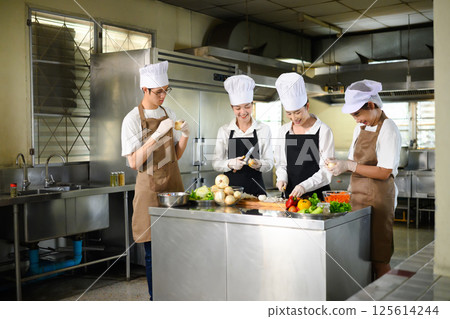 Culinary students learning together during a hands on cooking class in kitchen. Culinary students learning together during a hands on cooking class in kitchen. 125614244