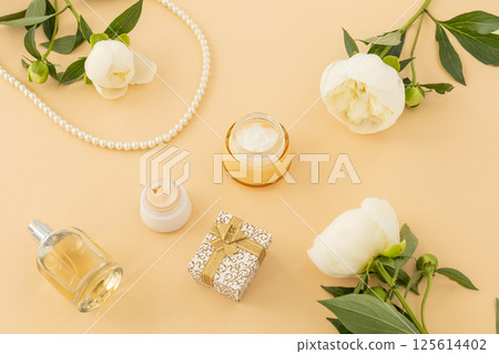 Women cosmetics set with costume jewelry and peony flowers. 125614402