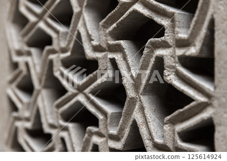 Close up of Arabic geometric pattern featuring interconnected symmetries 125614924