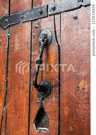 Rustic door knocker on a wooden surface, Baku Rustic door knocker on a wooden surface, Baku 125614929