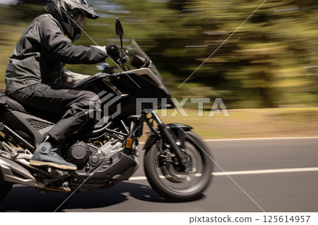 Close-up of Motorcycle Rider in freeze Motion. Motion Blur Effect. Action Sports Shot of Touring Motorbike. 125614957